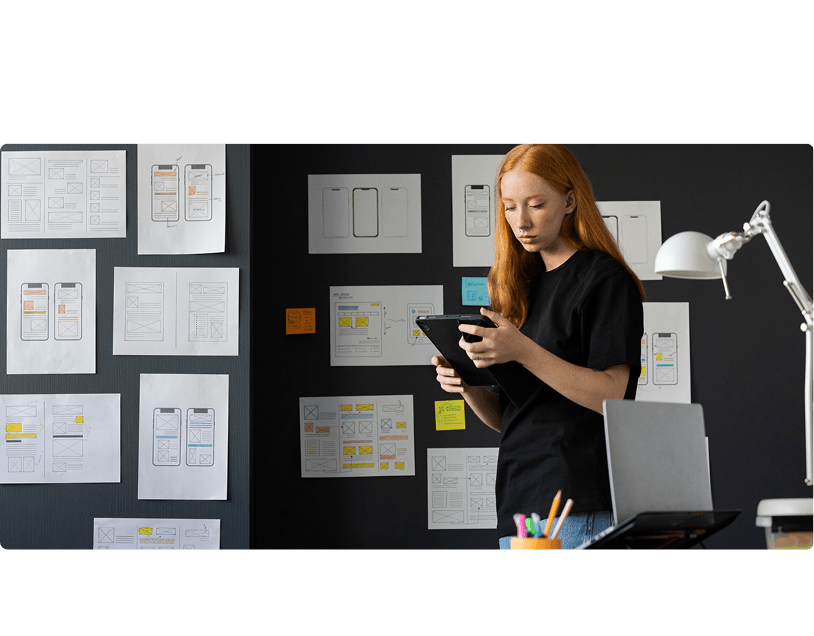 Designer reviewing mobile wireframes in a studio